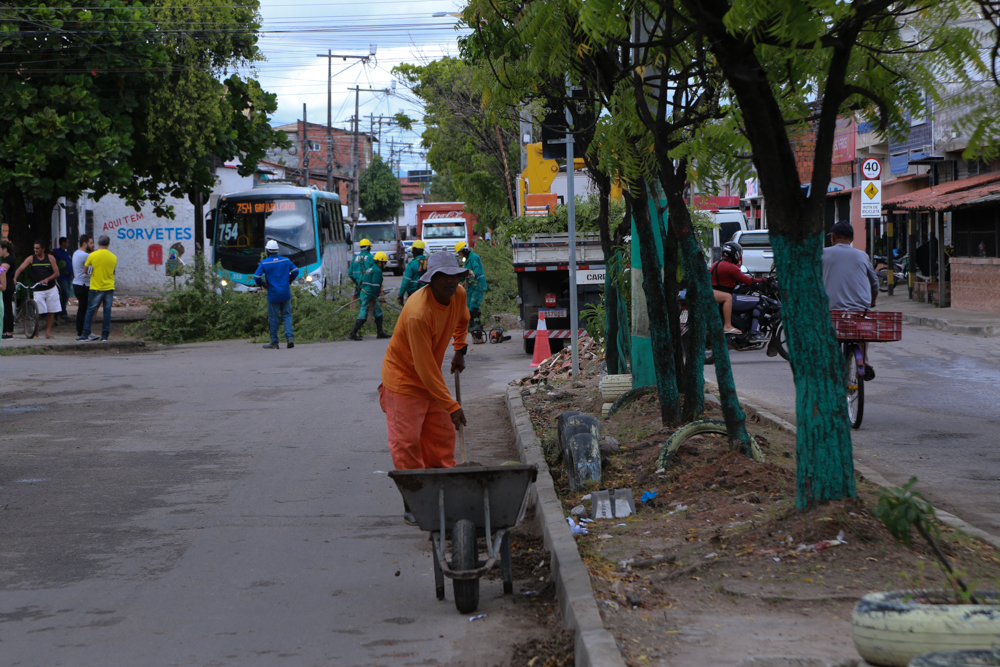 Homens varrendo uma via